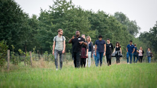 Pilgernde gehen über eine Wiese