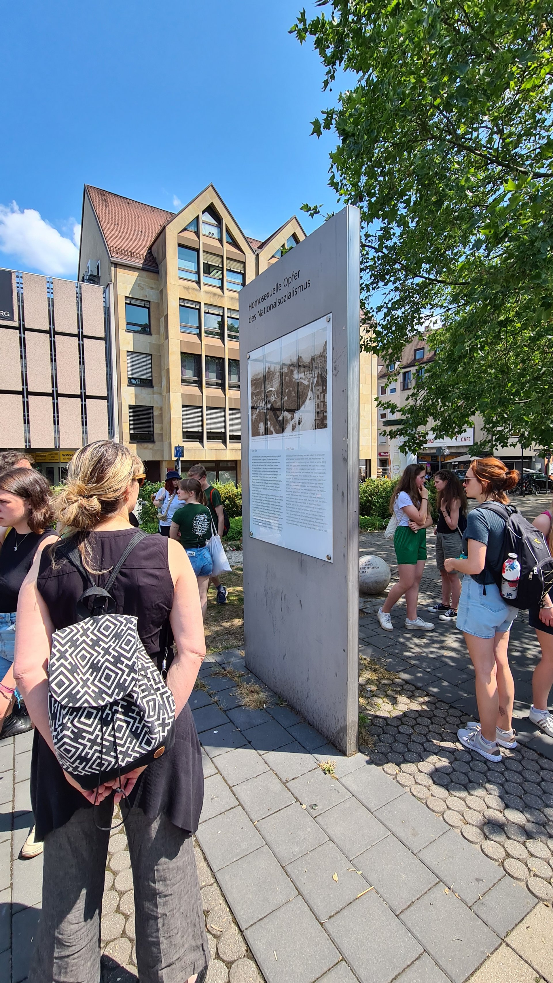 Menschen vor dem Mahnmal zum Gedenken an die homosexuellen Opfer des Nationalsozialismus
