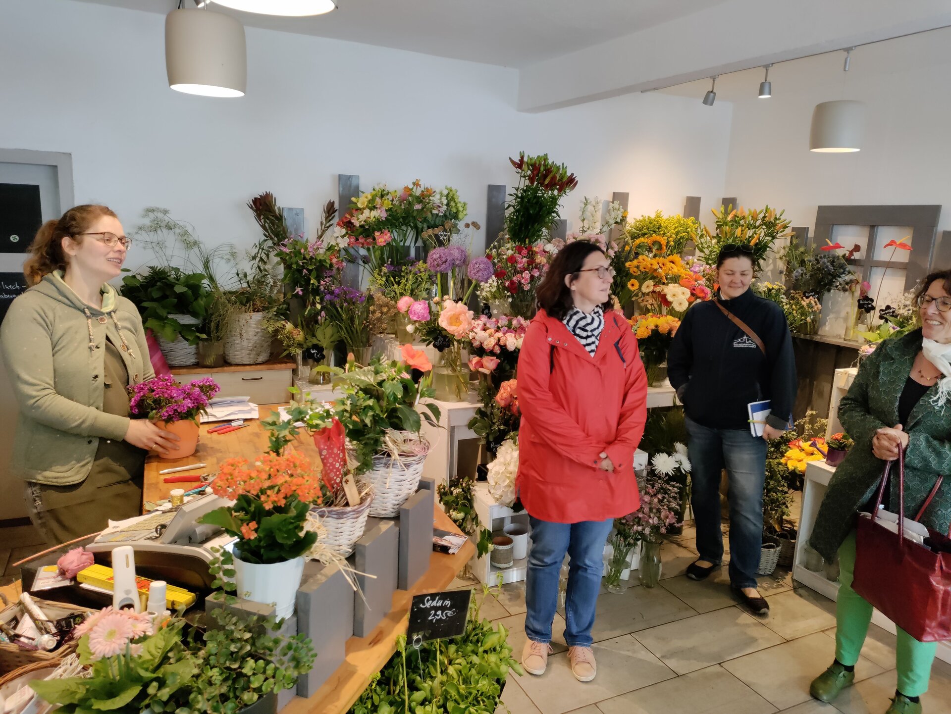 Blumengeschäft Gärtner mit Pilgergruppe