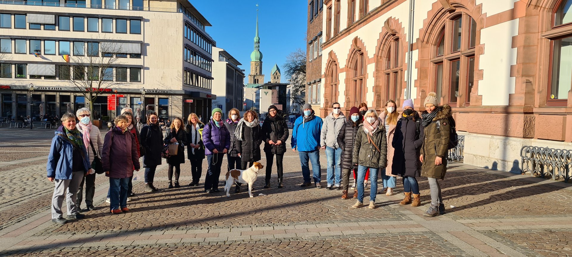Eine Menschengruppe steht in Dortmund auf einem Platz